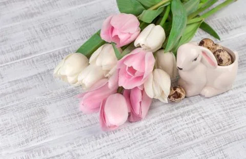 Easter composition with eggs, spring tulips and porcelain easter bunny on old Stock Photos