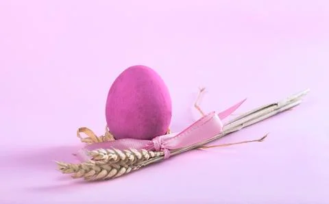 Easter composition with fuchsia painted egg and sheaf of wheat Stock Photos