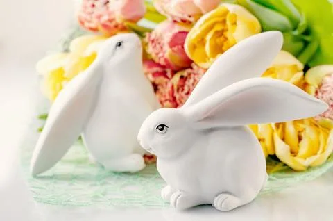 Easter composition on a light background. Cute white rabbits, yellow and pink Stock Photos