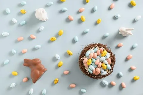Easter composition of nest with pastel chocolate eggs, sweets, chocolate bunn Stock Photos