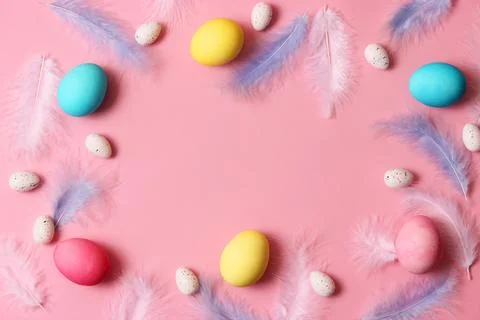 Easter composition of painted eggs and feathers on a colored background. Foto stock