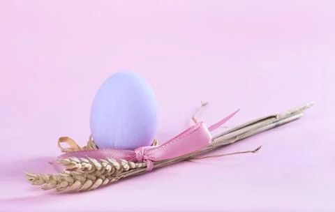 Easter composition with purple painted egg and sheaf of wheat Stock Photos