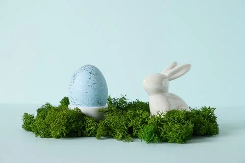 Easter composition with rabbit and pink egg on blue background. Stock Photos