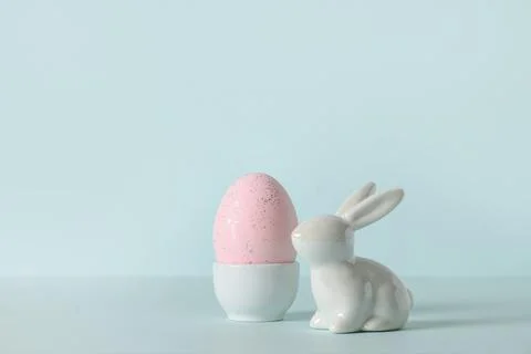 Easter composition with rabbit and pink egg on blue background. Stock Photos