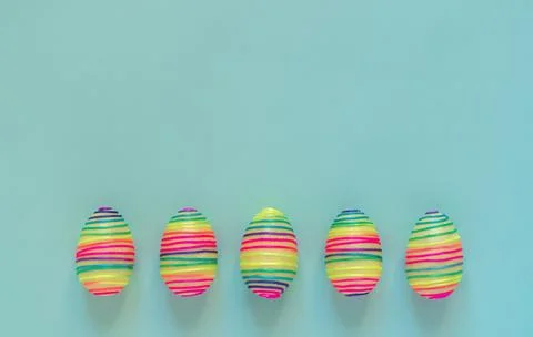 Easter composition with rainbow eggs on blue background 库存照片