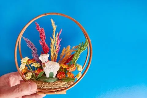 Easter composition with ram, grass and wooden base on blue background. East.. Stock Photos