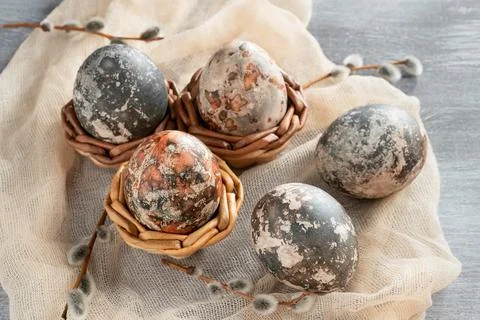 Easter composition - several marble eggs painted with natural dyes in a wicke Stock Photos