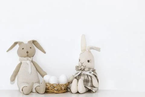 Easter composition with soft toys of hares and white eggs that are on the she Stock Photos