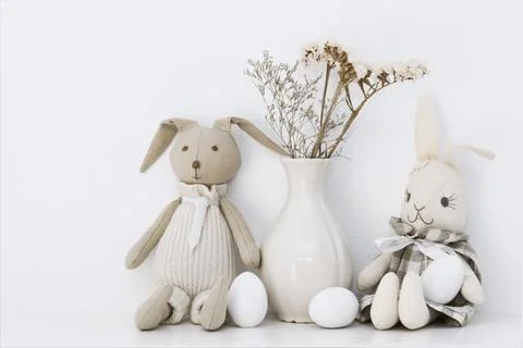 Easter composition with soft toys of hares and white eggs that are on the she Stock Photos