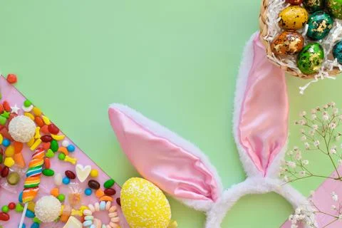 Easter composition with sweets and bunny ears space for text. Top view, flat Stock Photos