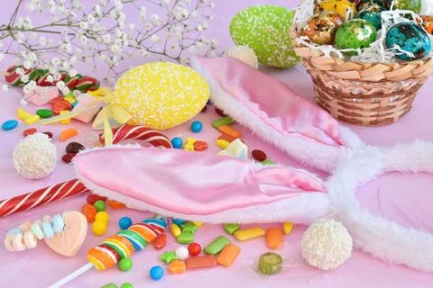 Easter composition with sweets, rabbit ears and tulips. Happy Easter greeting Photos