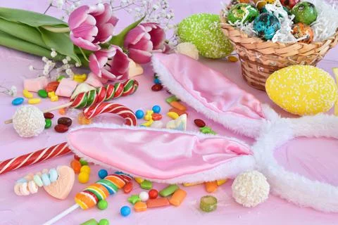 Easter composition with sweets, rabbit ears and tulips. Happy Easter greeting Stock Photos