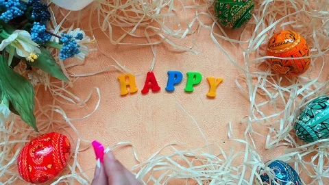 Easter composition, top view: phrase Happy Easter, Easter eggs, bouquet &amp; straw Stock Footage 103851449