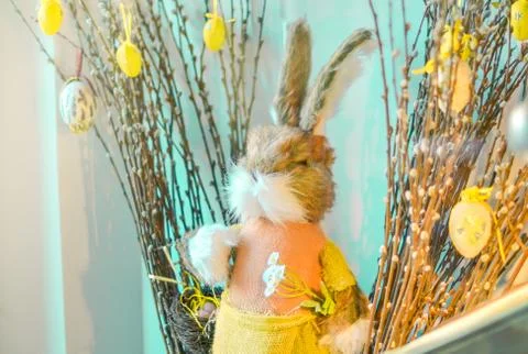 Easter composition with toy rabbit and eggs hanging on pussy-willow bouquet. Stock Photos