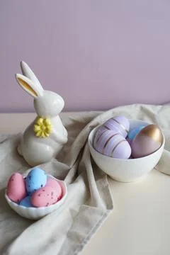 Easter composition with a white porcelain rabbit with multicolored eggs in porce 스톡 사진