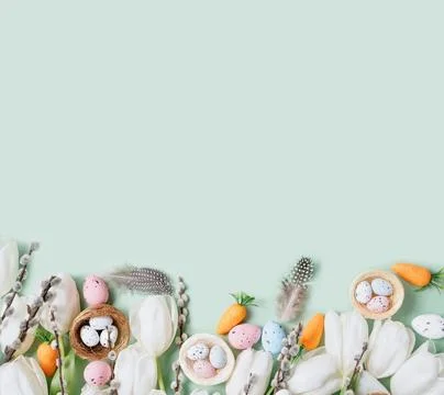 Easter Composition with White Tulips, Decorative Eggs, Carrots, and Feathers on Foto stock