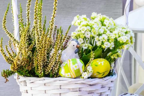 Easter composition on a white wicker basket with spring flowers, clay chicken Stock Photos