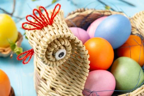 Easter composition - a wicker basket in the form of a chicken with colored eg Foto stock