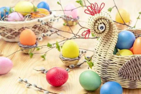 Easter composition - a wicker basket in the form of a chicken with colored eg Stock Photos