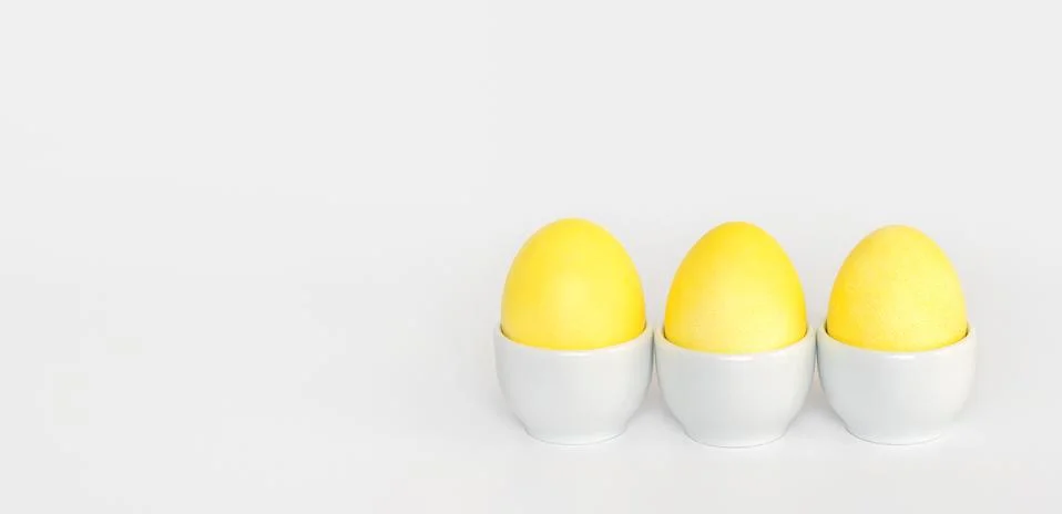 Easter composition with yellow chicken eggs on a white background.  Stock Photos