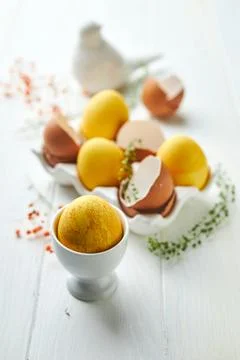 Easter composition with yellow eggs and flowers. Natural dyed colorful eggs a Stock Photos