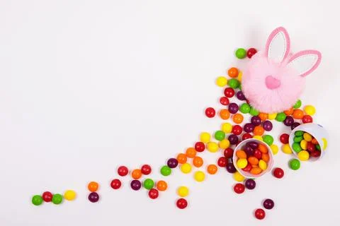 Easter concept, candy pills, egg, pink rabbit head toy on white background Stock Photos