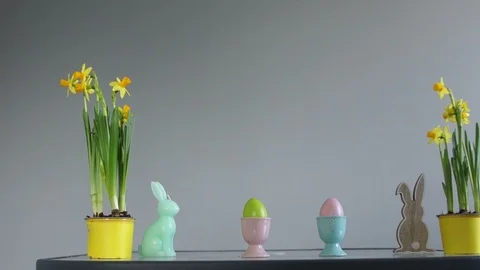 Easter concept. Daffodils in yellow pots, Easter eggs and rabbit figurines Stock Footage 101439543