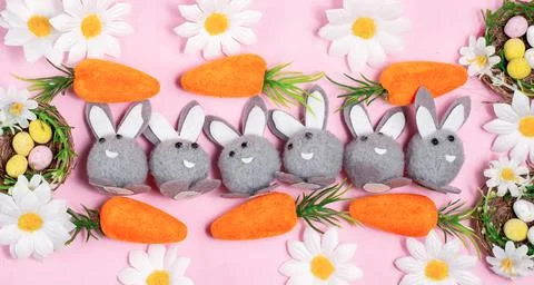 Easter concept. Easter bunnies with carrots and Easter eggs. Stock Photos