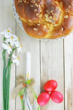 Easter concept with easter candle, red eggs, tsoureki and flowers Stock Photos