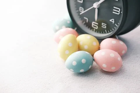 Easter concept with egg and alarm clock on white background. Stock Photos