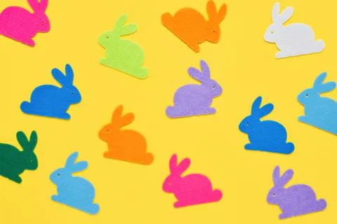 Easter concept. Multi-colored figurines of Easter bunnies on a yellow background Foto stock