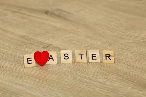 Easter concept with red heart replacing letter on wooden background Stockfoto's