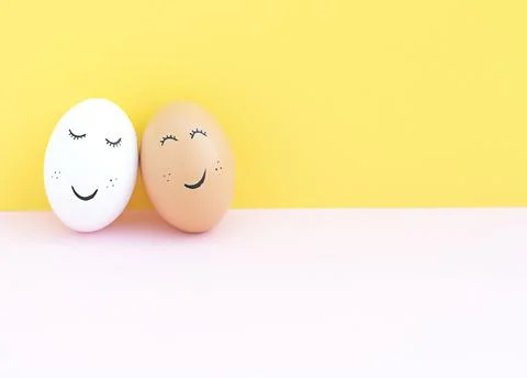 Easter concept. Two creative white and brown eggs with painted eyes and a mou Stock Photos