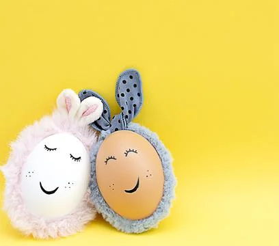 Easter concept. Two creative white and brown eggs with rabbit ears and painte Stock Photos