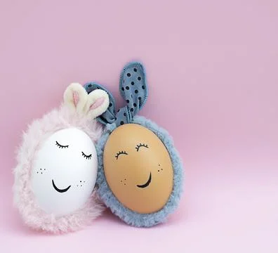Easter concept. Two creative white and brown eggs with rabbit ears and painte Stock Photos