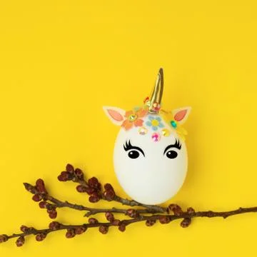 Easter concept. Unicorn shaped egg. And twigs with buds and blooming leaves.O Stock Photos