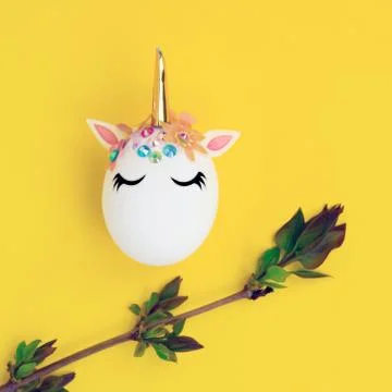 Easter concept. Unicorn shaped egg. And twigs with buds and blooming leaves.O Stock Photos