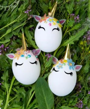 Easter concept. Unicorns in the shape of an egg on a background of green gras Stock Photos