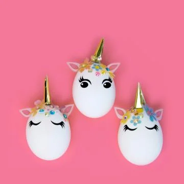 Easter concept. Unicorns in the shape of an egg on a pink pastel background. Stock Photos