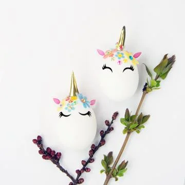 Easter concept. Unicorns shaped eggs. And twigs with buds and blooming leaves Stock Photos