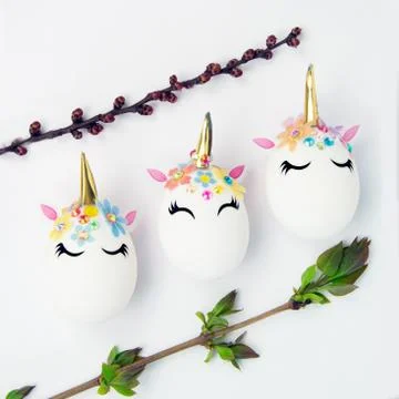 Easter concept. Unicorns shaped eggs. And twigs with buds and blooming leaves Stock Photos