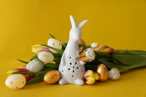 Easter concept. White Easter bunny and tulips on a yellow background with spa Stock-Fotos