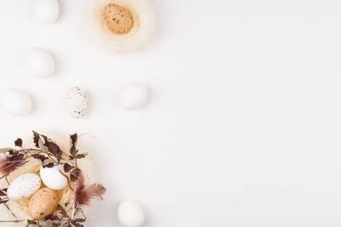 Easter concept. White eggs in stylish straw nest decorated with leaves Stock Photos