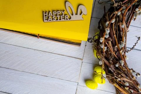 Easter concept. Yellow notepad with a sign of the sorly Easter and a wreath s Stock Photos
