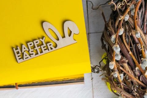 Easter concept. Yellow notepad with a sign of the sorly Easter and a wreath s Stock Photos