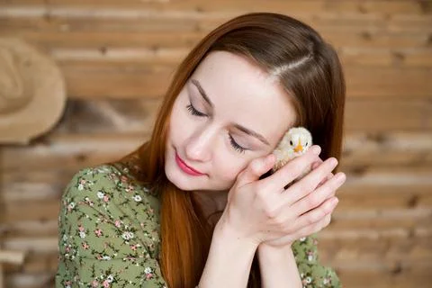 Easter concept. Young red haired girl holding cute little chicken Stock Photos