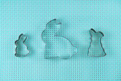 Easter cookie cutters in the shape of bunny on blue background, Foto stock