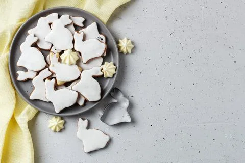 Easter cookies in the form of a rabbit on a gray plate with yellow textiles Stock Photos