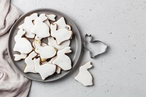 Easter cookies in the shape of a rabbit on a gray plate with gray textiles Stock Photos