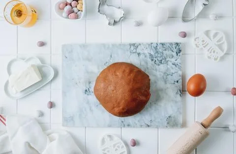 Easter cooking background. Dough, rolling pin, egg, butter, and different E.. Stock Photos